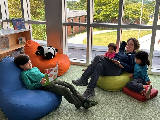 Woman reading to children in children's reading area.